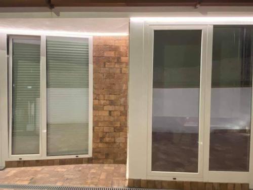 two glass doors with blinds on a brick wall at Risorgimento House in Isernia