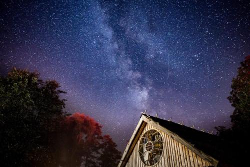 a church with a night sky with the milky way at Siedlisko Sobibór in Sobibór