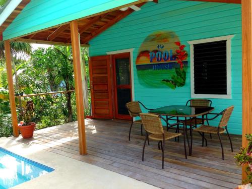 a house with a table and chairs on a deck at Hummingbirds Cabins in Caye Caulker