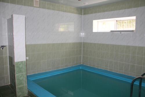 a bathroom with a blue tub in a room at Hotel Katrin in Vinnytsya