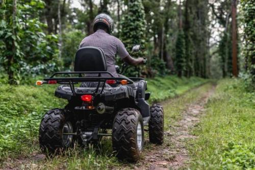 a man riding a four wheeler down a dirt road at Tusker Trails - A LuxUnlock Private Retreat in Suntikoppa