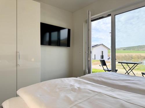 a bedroom with a bed and a tv on the wall at Diemelblick 22 - SEEBLICK in Heringhausen