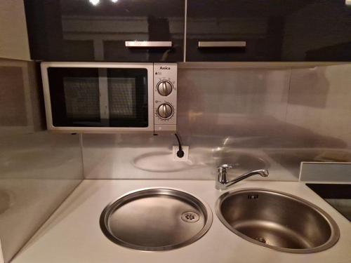 a kitchen with a sink and a microwave at Nordseeperle in Hooksiel