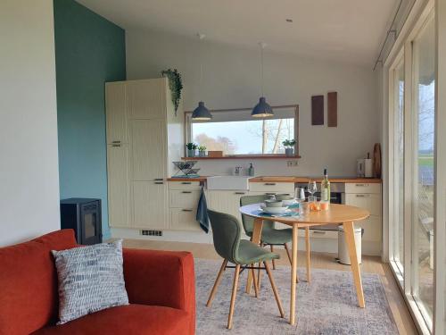 a living room with a table and a kitchen at Het Groene uitzicht in Bantega