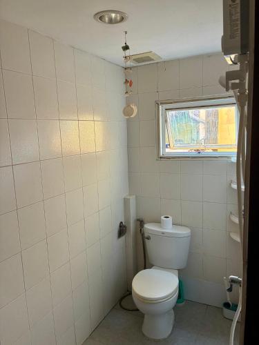 a bathroom with a toilet and a window at Farang house in Pattaya