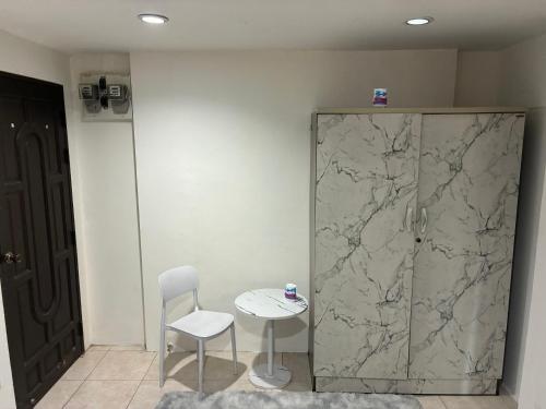 a table and a chair next to a marble wall at Farang house in Pattaya