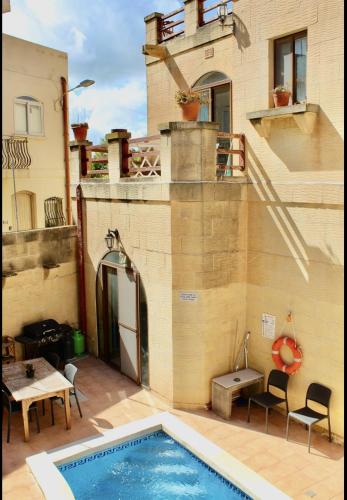 a house with a swimming pool on a patio at Shamrock House in Qala