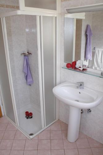 a white bathroom with a sink and a shower at Hotel Calipso in Lido degli Estensi