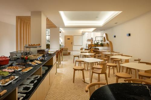 a restaurant with tables and chairs and a buffet at Hotel das Salinas by Alboi Group in Aveiro