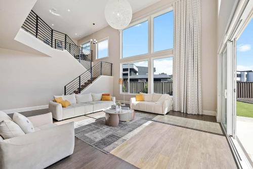 a living room with white furniture and large windows at Charming 5-Bedroom House in Harrison