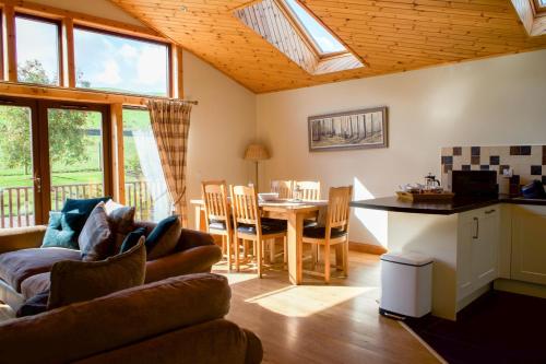 a living room with a couch and a table at Plum Tree Lodge in Errol