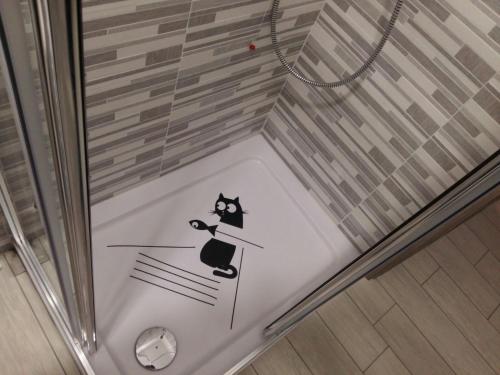 a glass shower with a black cat sticker on it at Affittacamere Erbagatta in Erba