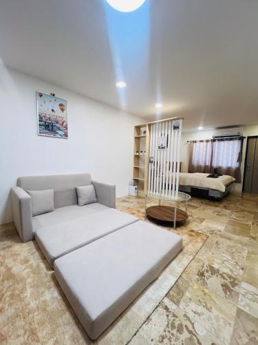 a living room with a large bed and a couch at Brand new furnished studio Apartment near old Town in Phuket