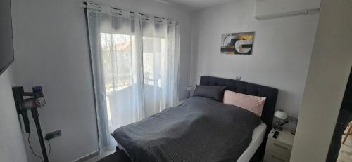 a bedroom with a bed in front of a window at DaRo-Appartments in Asprovalta