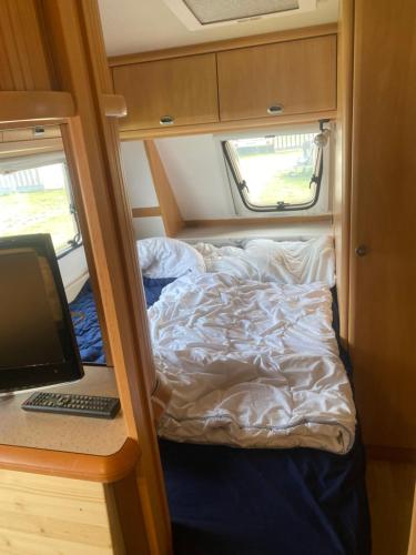 a camper with a bed and a computer in it at Zillerstadl - 5 Sterne Erlebnisresort Aufenfeld, Aschau in Aschau