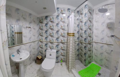 a bathroom with a white toilet and a sink at Safo Hotel Turkestan in Türkistan