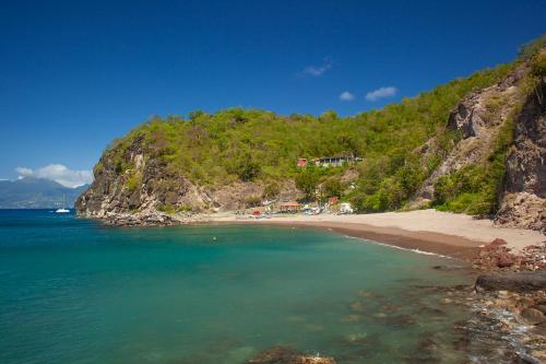 a view of a beach with the ocean and a mountain at LA DILETTANTE - Maison Créole de 130m2 - Clim - Tout à Pied in Terre-de-Bas