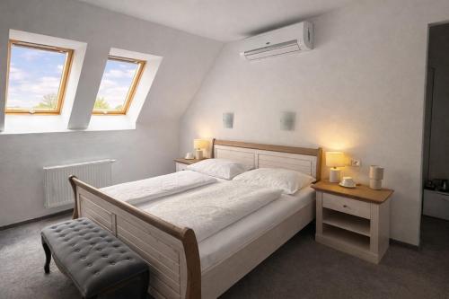 ein Schlafzimmer mit einem großen Bett und zwei Fenstern in der Unterkunft Saint Michael Boutique & Garni Hotel Trnava in Trnava