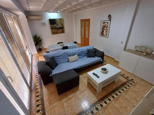 a living room with a blue couch and a table at PARRA HOME y Garaje, Algemesi Home in Algemesí