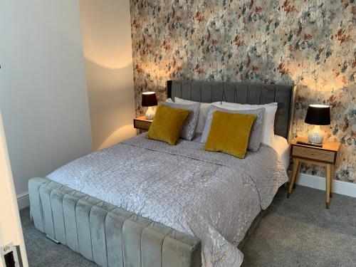 a bedroom with a bed with two lamps on tables at Ashfield Boutique Stays in Altrincham