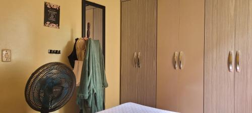a bedroom with a fan next to a closet at Joy Hostel in Salvador