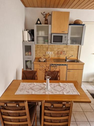 a kitchen with a wooden table with a table cloth on it at Ferienwohnung Drechsel in Olbernhau