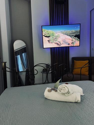 a room with a bed with a towel and a tv at To Balkoni Thanos in Thános