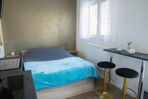 a small bedroom with a bed and two stools at Garden Spa in Caudebec-lès-Elbeuf
