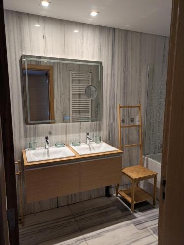 a bathroom with two sinks and a mirror and a chair at Quarportugal in São Martinho do Porto