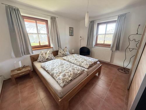 a bedroom with a bed and two windows at Ferienwohnung Ott in Weißenburg in Bayern
