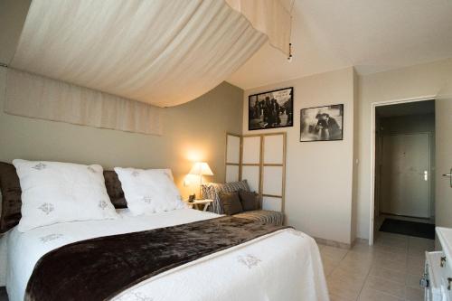une chambre avec un grand lit dans une pièce dans l'établissement Les Gémeaux, à Avignon