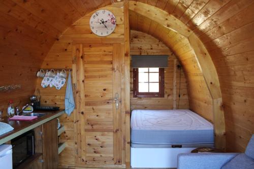 a small bedroom in a log cabin with a clock at Quinta Da Devesa B1 in Vinhais