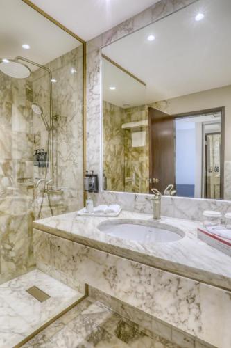 a bathroom with a sink and a large mirror at Regency Palace Amman in Amman