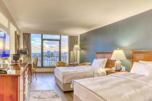 a hotel room with two beds and a window at Regency Palace Amman in Amman