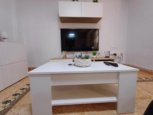 a white island in a kitchen with a tv on the wall at PARRA HOME y Garaje, Algemesi Home in Algemesí