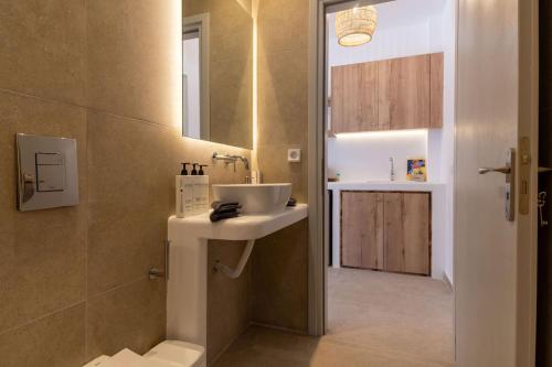 a bathroom with a sink and a mirror at Aqua Cozy Suites in Perissa