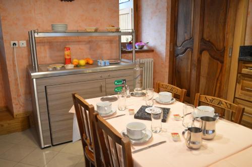 une cuisine avec une table et des chaises dans l'établissement Hôtel La Montagne Fleurie, à Barèges