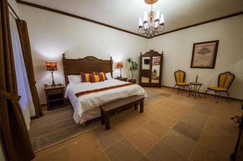 a bedroom with a bed and a table and chairs at La Casona Minera in Mineral de Pozos