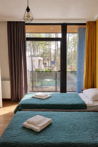 two beds in a bedroom with a large window at Black Sea Gemini in Ureki