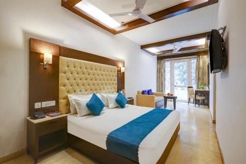 a hotel room with a bed and a television at Hotel The Metropolis Tourist Near Connaught Place And Ramakrishna Ashram Marg Metro Station in New Delhi