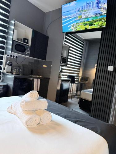 a hotel room with towels on a bed with a television at Islington Romantic Studio - Jacuzzi & Garden in London