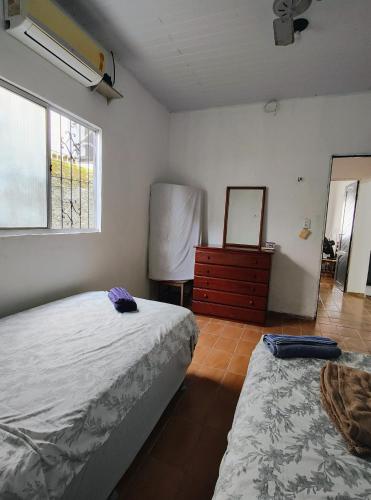 a bedroom with two beds and a dresser and a mirror at Casa em Mosqueiro com Piscina in Belém