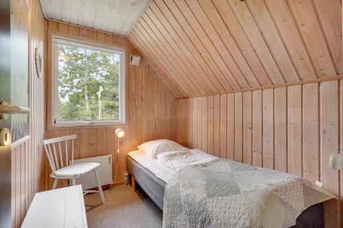 a bedroom with a bed in a wooden room at Søndervang 4 in Nørre Nebel