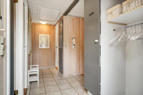 a hallway with wooden walls and a door with a chair at Søndervang 4 in Nørre Nebel