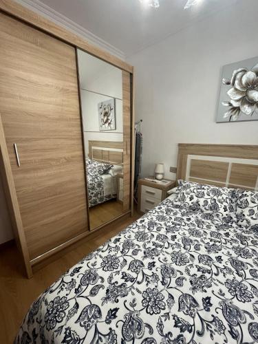 a bedroom with a black and white bed and a mirror at Rúa da Igrexa Miño in Miño