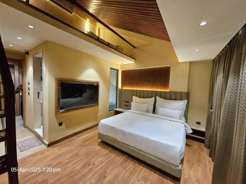 a bedroom with a white bed and a flat screen tv at THE GRAND SUNCITY HOTEL AND RESORT, Bhopal in Bhopal