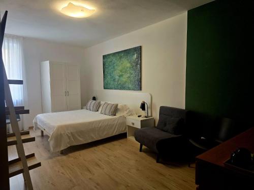a bedroom with a bed and a chair and a couch at Alle Porte in Riva del Garda