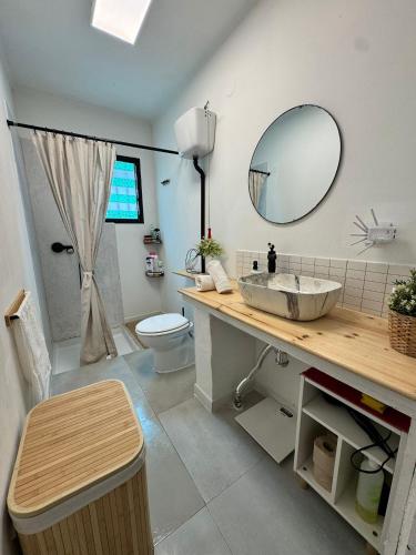 a bathroom with a sink and a toilet and a mirror at Casa en la montaña con jacuzzi exterior y piscina in Alcántara de Júcar