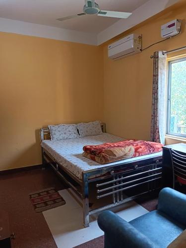 a bedroom with a bed in a room with a window at Ma manasha lodge in Guwahati
