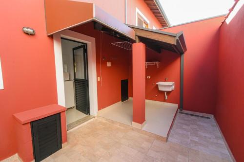 a bathroom with an orange wall with a toilet in it at Vila dos Pinheiros 1 in Serra Negra